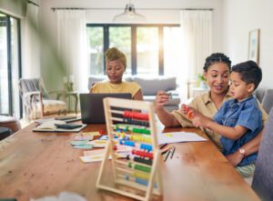 Child, homework help and math in home with mom and abacus for development growth. Young boy, student and lgbt parents with education support and learning talk at a house with teaching kid to study